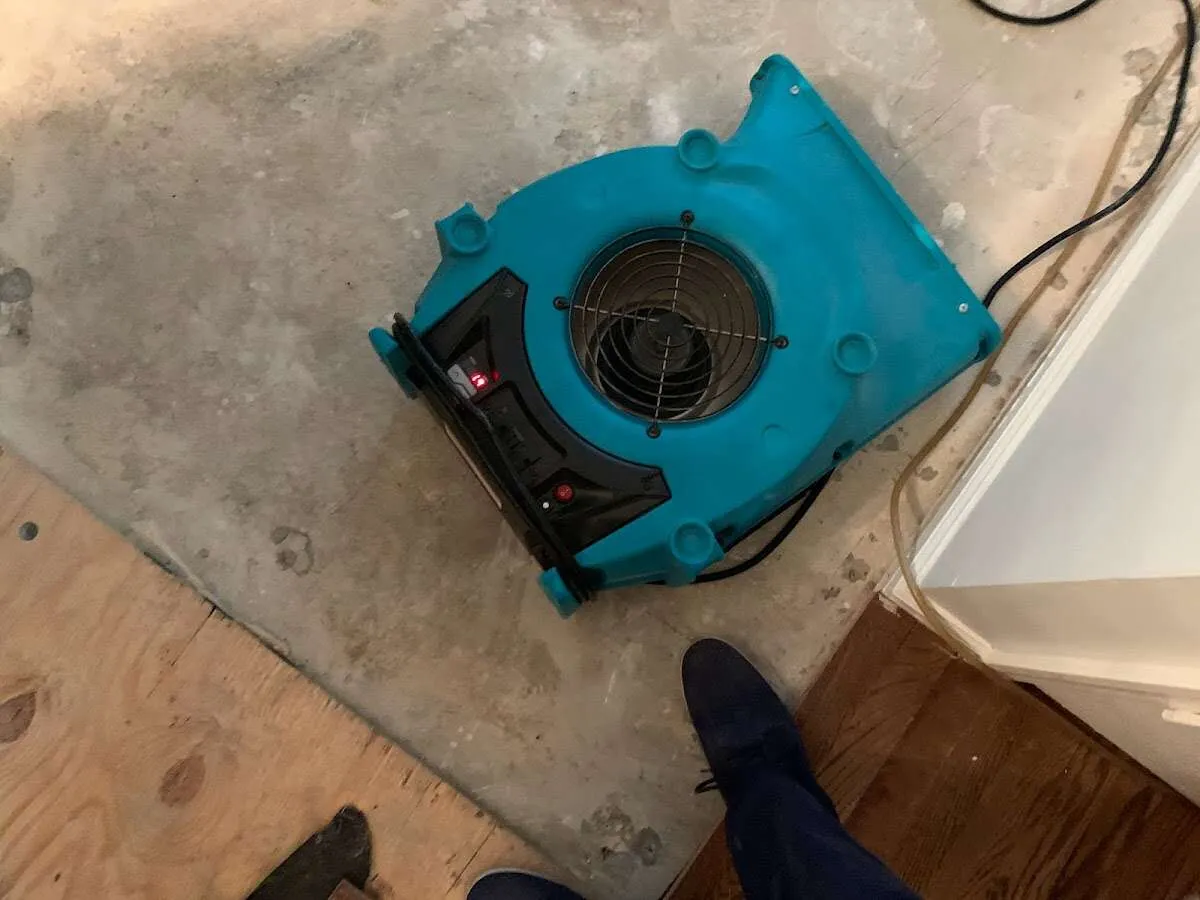 Air mover drying subfloor during Commercial Water Damage Restoration in West York